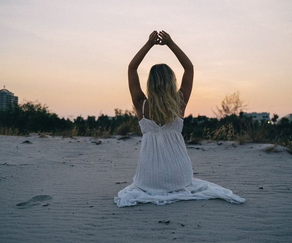 Silhouette of a person meditating at sunset, showing peace and tranquility.